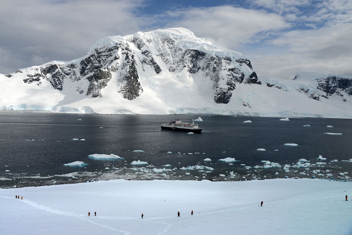 12D Tourists Descend From The Top Of Danco Island To Reboard The Ship With Mount Britannia On Ronge Island Behind On Quark Expeditions Antarctica Cruise